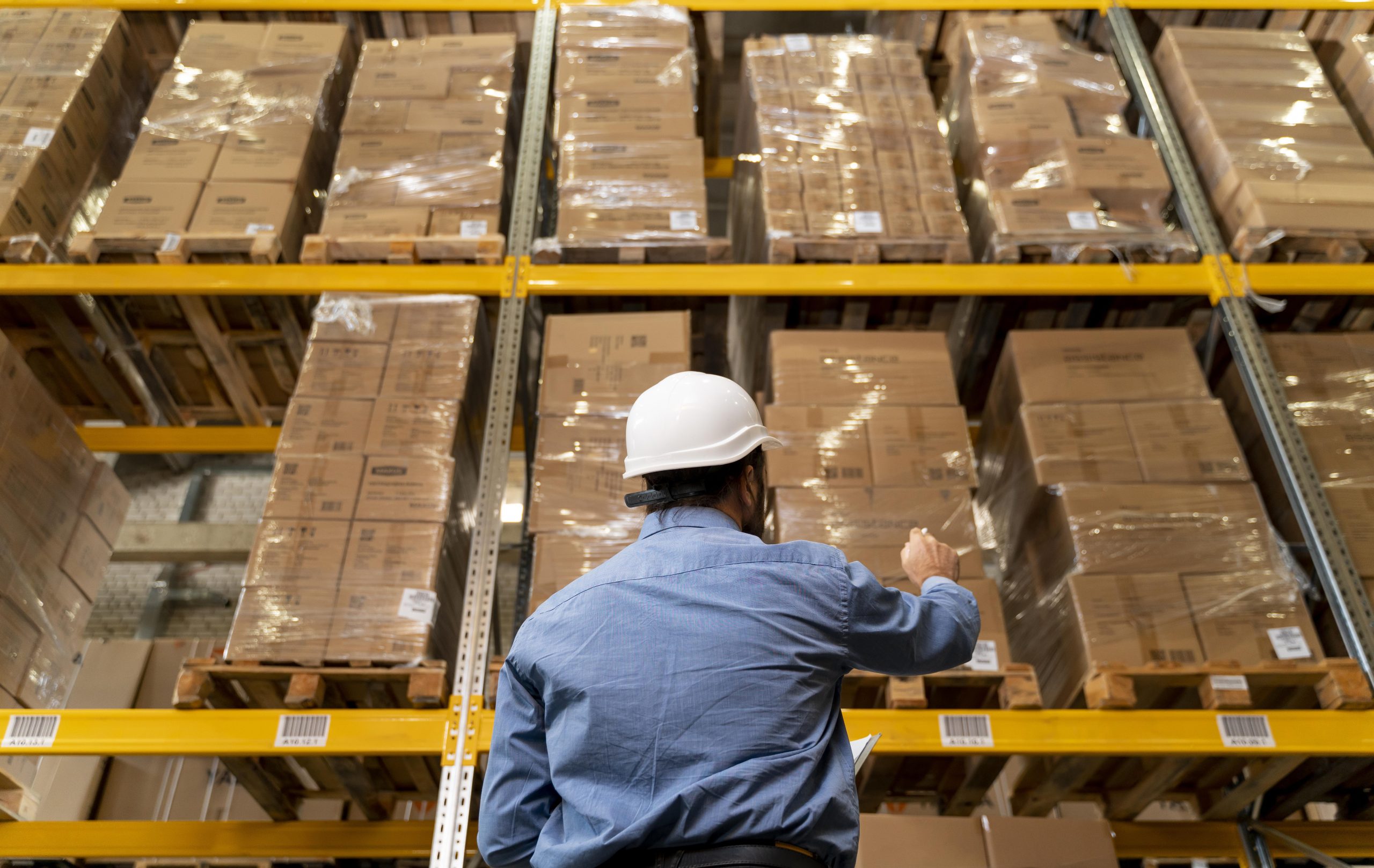 man with helmet working warehouse scaled